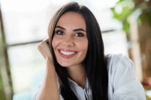 Portrait of adorable satisfied cheerful girl beaming smile arm touch cheekbone have good mood free time weekend flat inside